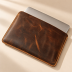 Slim brown leather MacBook case with laptop partially inserted