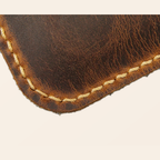 Close-up hand sewn stitching and distressed leather edge