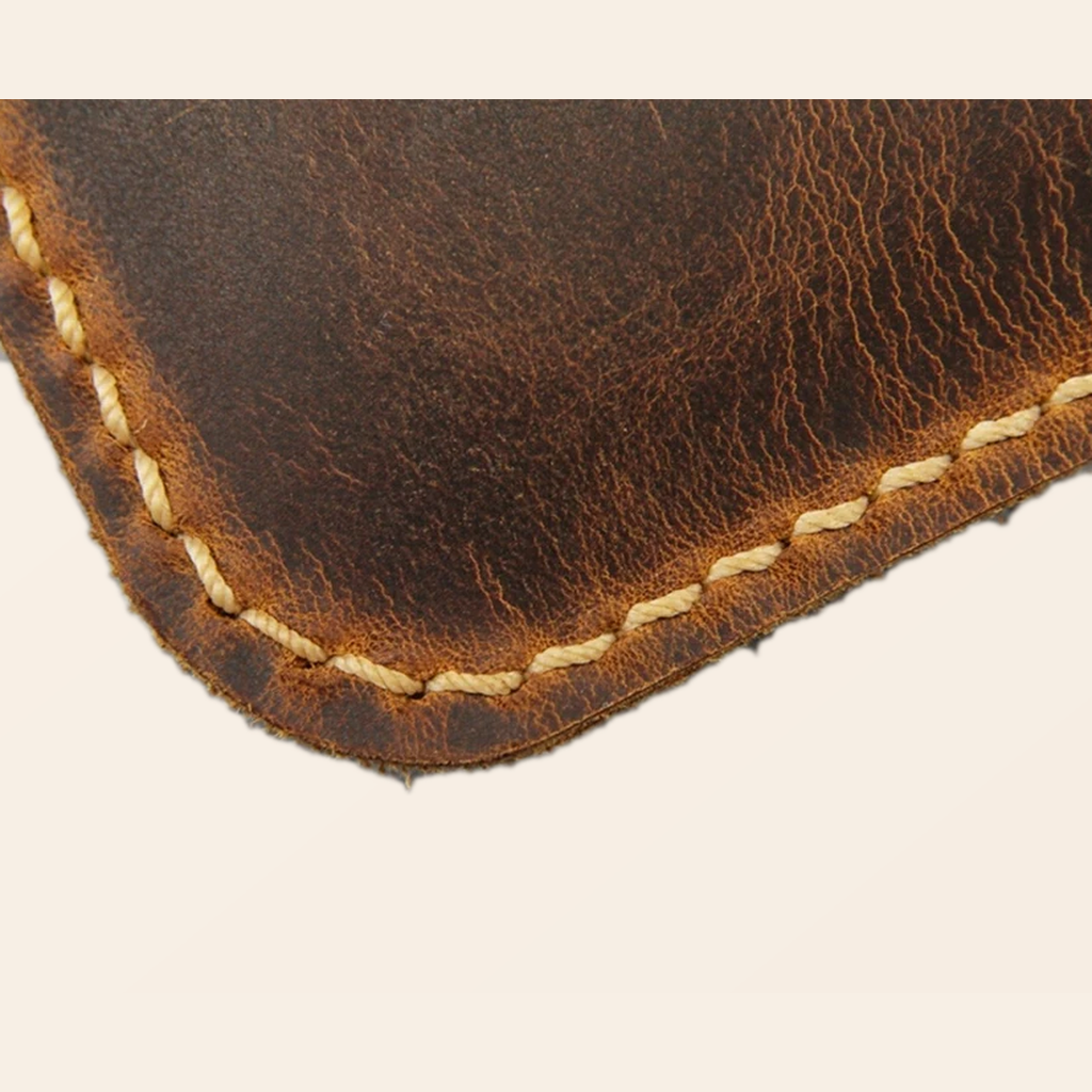 Close-up hand sewn stitching and distressed leather edge