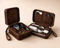 Brown travel case with compartments for electronic devices on a beige background