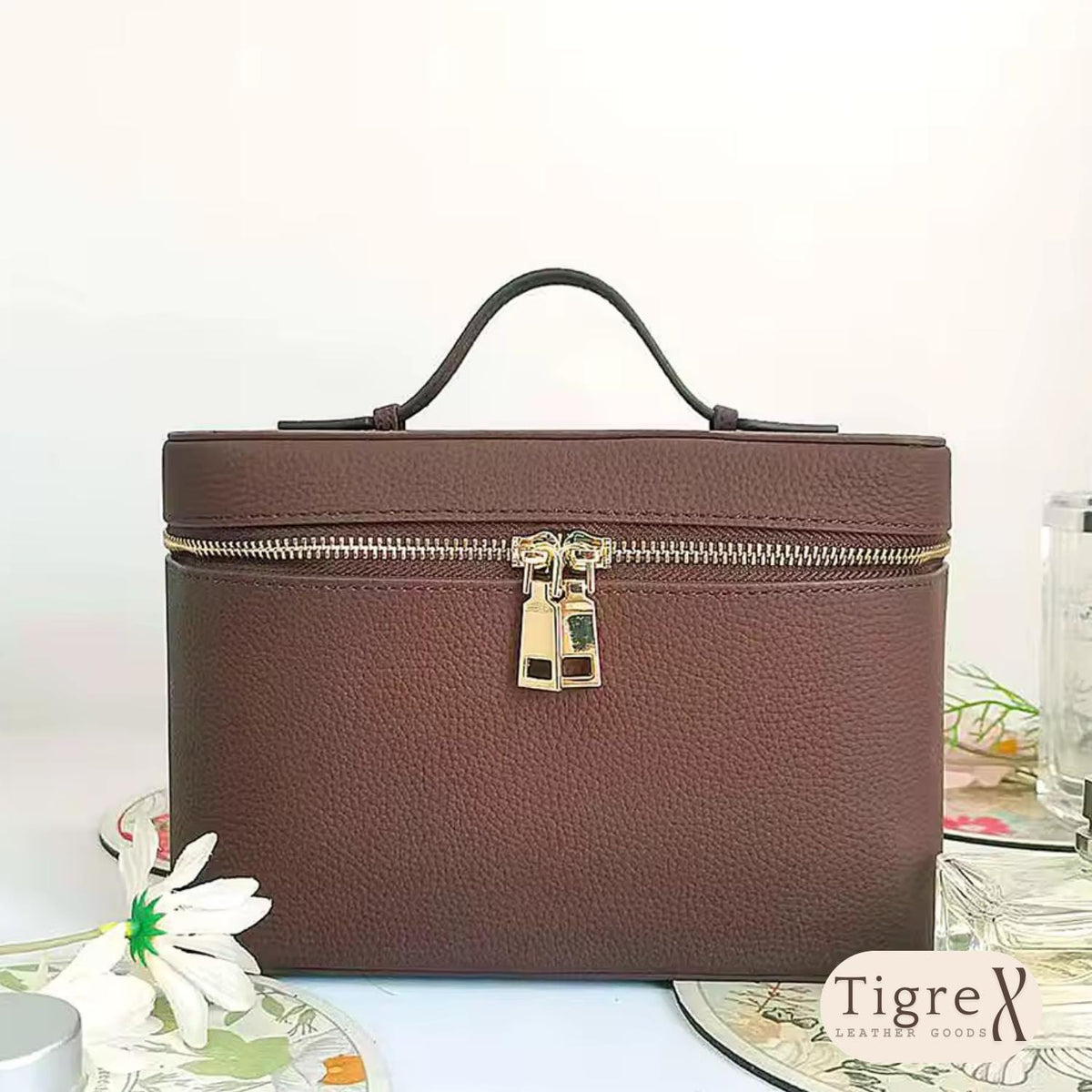 Close-up of dual gold zipper on a leather cosmetic bag
