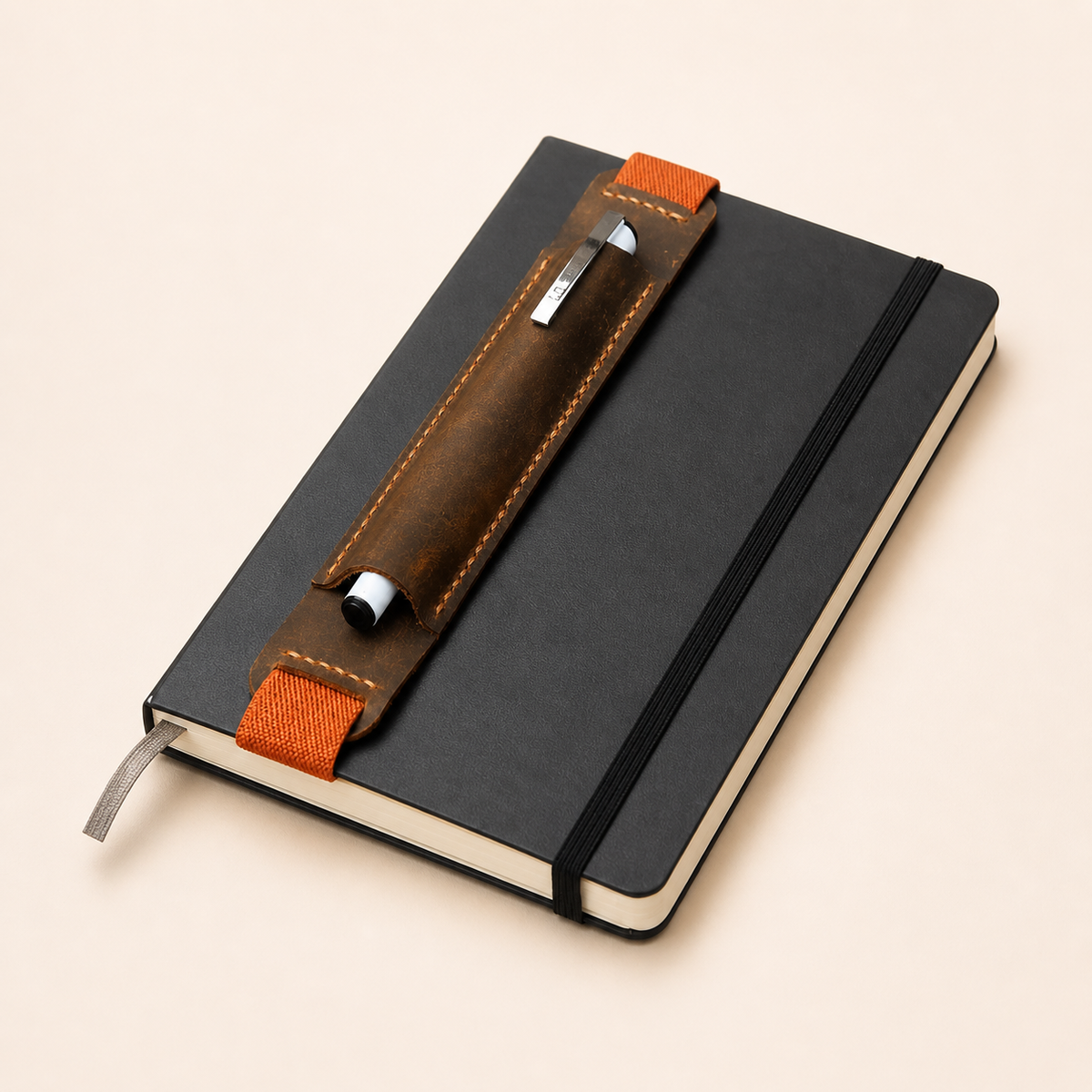 Leather pen holder shown wrapped around a notebook