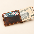 Hand-stitched brown leather minimalist money clip wallet showing banknotes and card storage