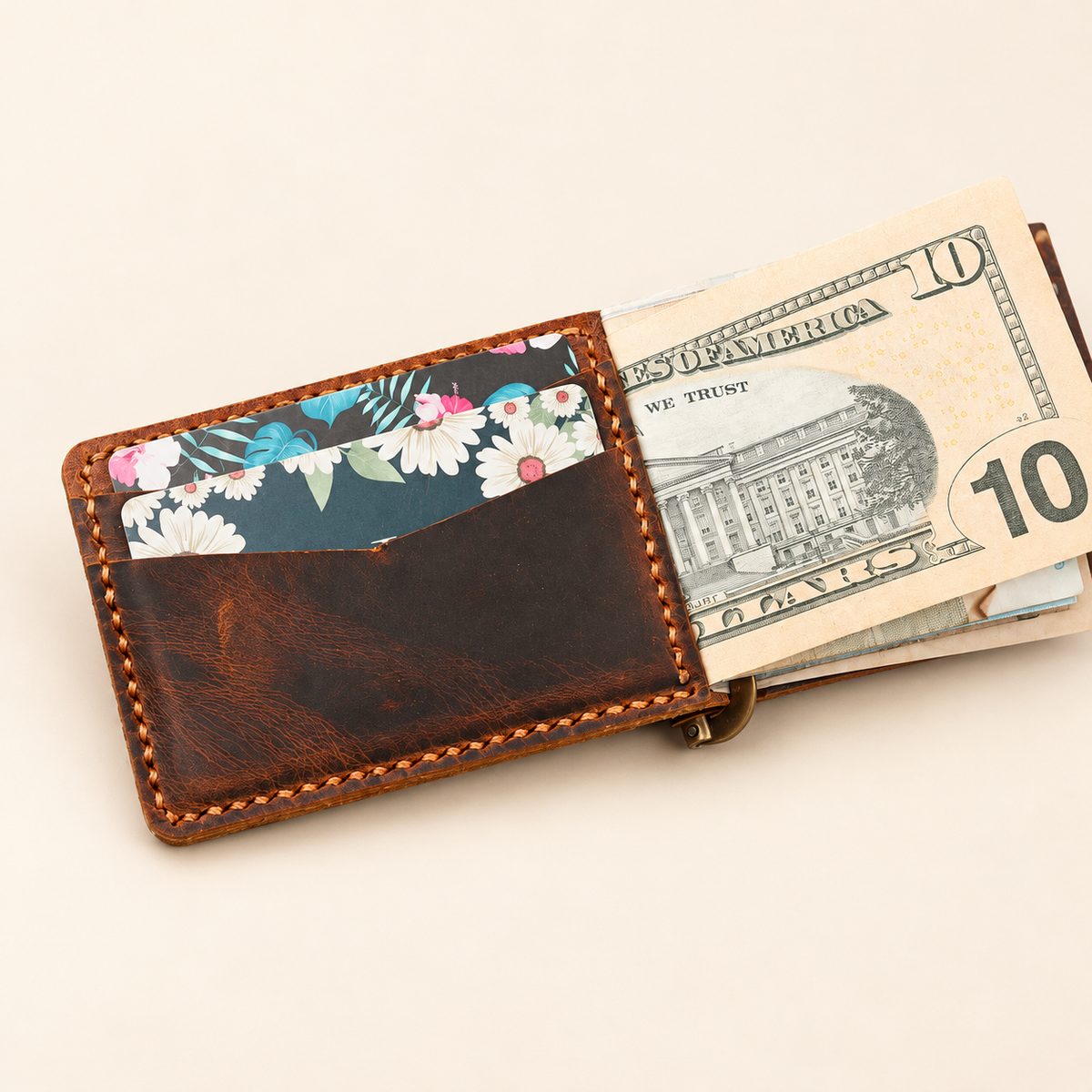 Hand-stitched brown leather minimalist money clip wallet showing banknotes and card storage